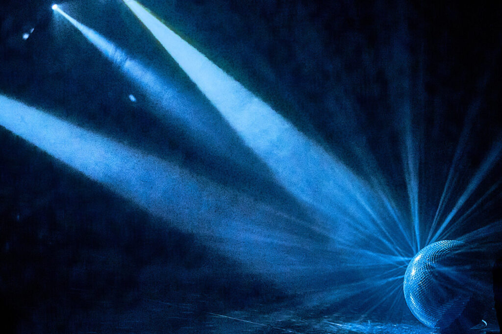 eine Diskokugel auf dem Boden wird von mehreren Scheinwerfern mit blauem Licht angeleuchtet