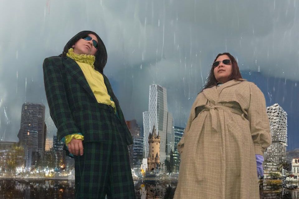 In a collage, two persons are bending backwards in the rain, in front of a Frankfurt skyline. One is wearing a checkered suit and a yellow blouse, the other a trench-coat and boots. 